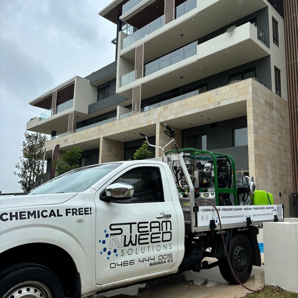 Steam N Weed Solutions pressure washing truck parked beside a commercial building in Central Coast NSW
